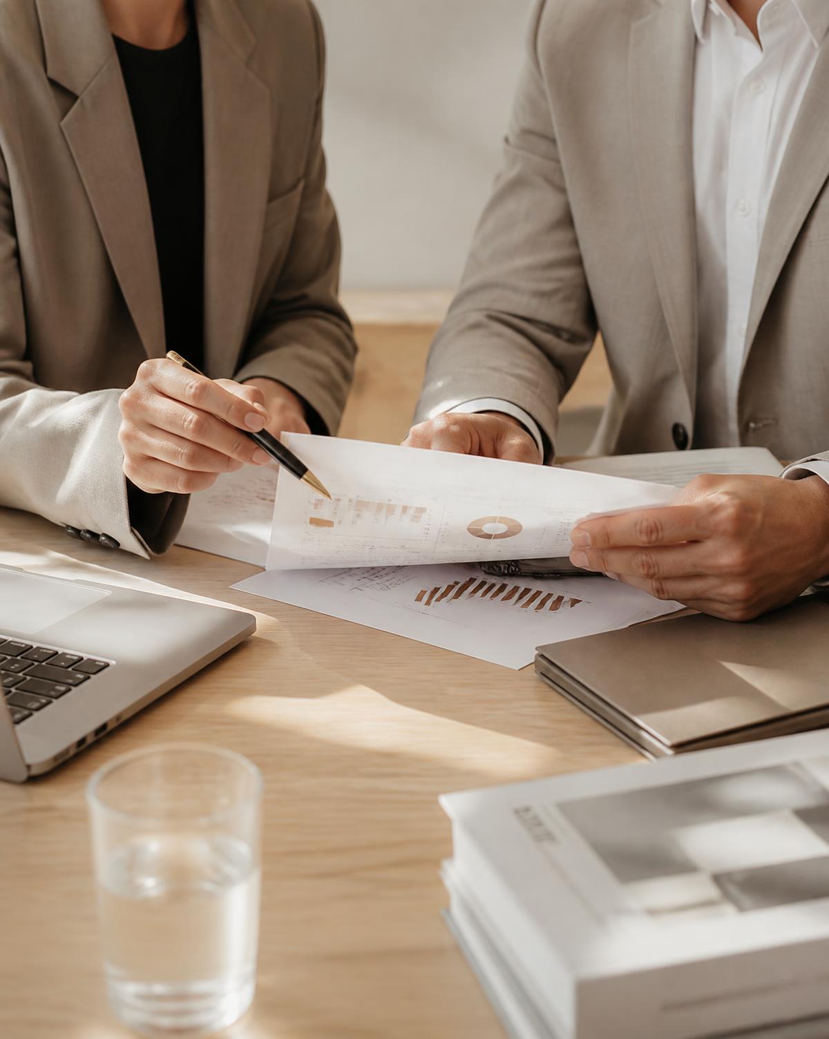 Deux professionnels analysant des documents de stratégie sur un bureau clair